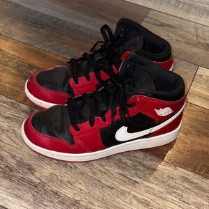 Nike Air Jordan 1 Mid in the black, white, and Gym Red